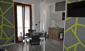 Une cuisine moderne équipée d’un four encastré, d’un évier et d’un téléviseur à écran plat fixé au-dessus du plan de travail.