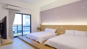 A hotel room with two beds, a TV, and a large window with curtains. - Sun Day B&B (Magong)