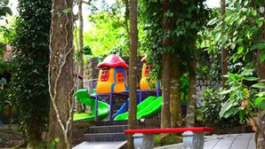 A playground with colorful slides and a red bench.