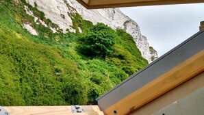 A room with a view of a rocky cliff and lush greenery. - Dover Adventure Backpackers (Dover)