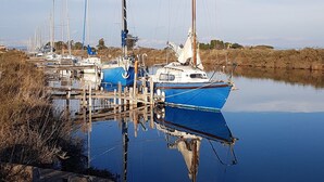 A calm lake with several sailboats docked at a wooden pier. - Studio LE COLONEL, in the heart💖of the beautiful village of Marseillan  (Marseillan)