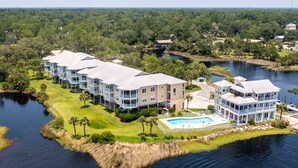 A waterfront hotel with multiple buildings, a swimming pool, and a dock. - Gulf Breeze Condo #207- Private Boat Ramp! WiFi! Docks to be completed May 2026! (Steinhatchee)