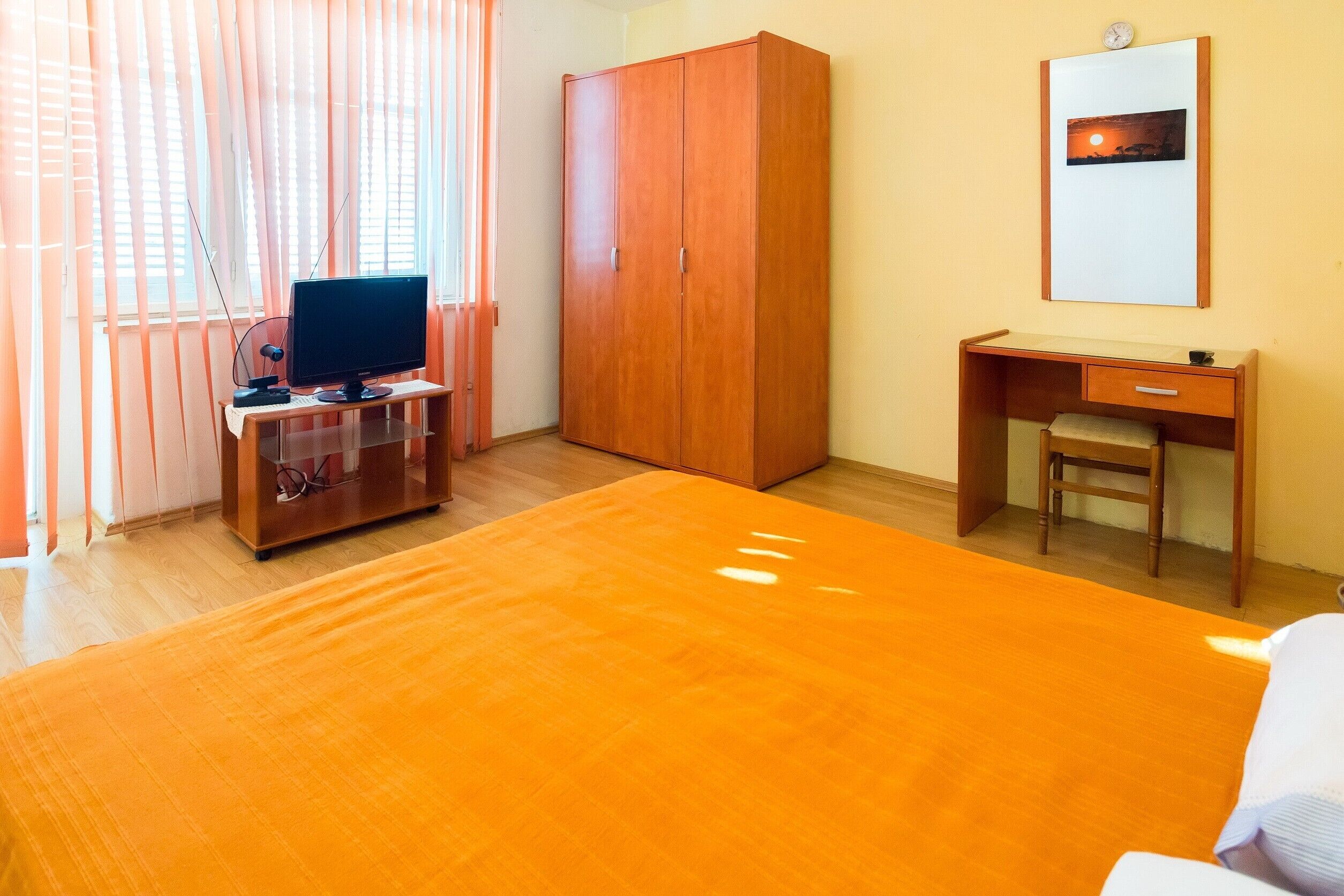 Une chambre d’hôtel équipée d’un lit, d’un bureau, d’une armoire et d’un téléviseur.