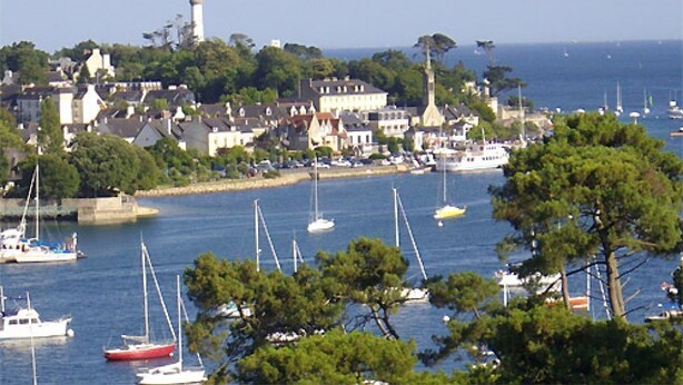 A coastal town with a lighthouse, boats, and houses along the shore. - Large studio, feet in the water! (Bénodet)