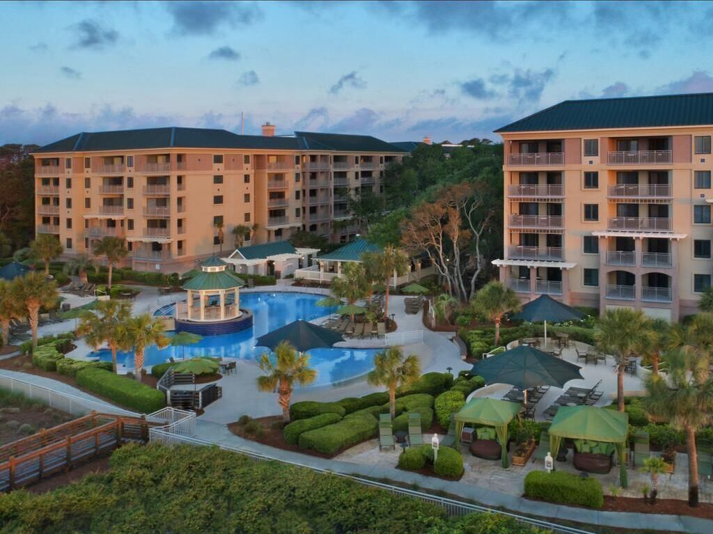 Un hôtel comprenant plusieurs étages, une piscine et des espaces de détente en plein air.
