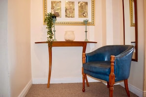 Cozy retreat with a wooden side table, comfortable armchair, and a beautiful potted plant.
