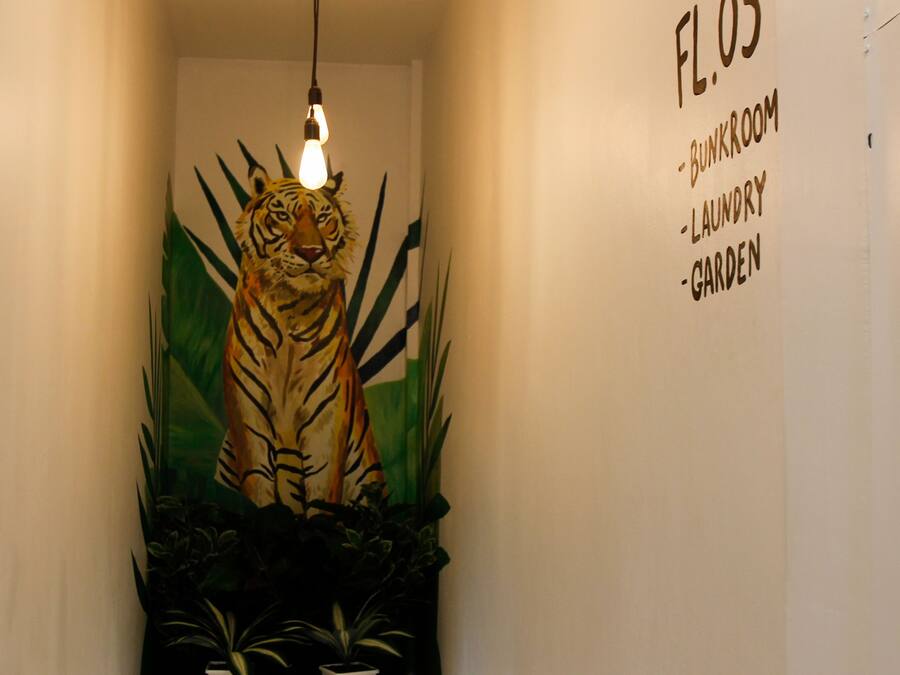 A hallway with a wall-mounted sign listing rooms: Bunkroom, Laundry, Garden.