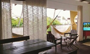 Una habitación con hamaca, muebles de madera y televisor.