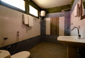 A compact bathroom with a toilet, sink, and shower.