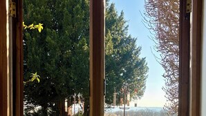 A room with a large window overlooking a grassy area with trees and a clear sky. - 5*Gold One bed near Ludlow, The Granary (Kidderminster)