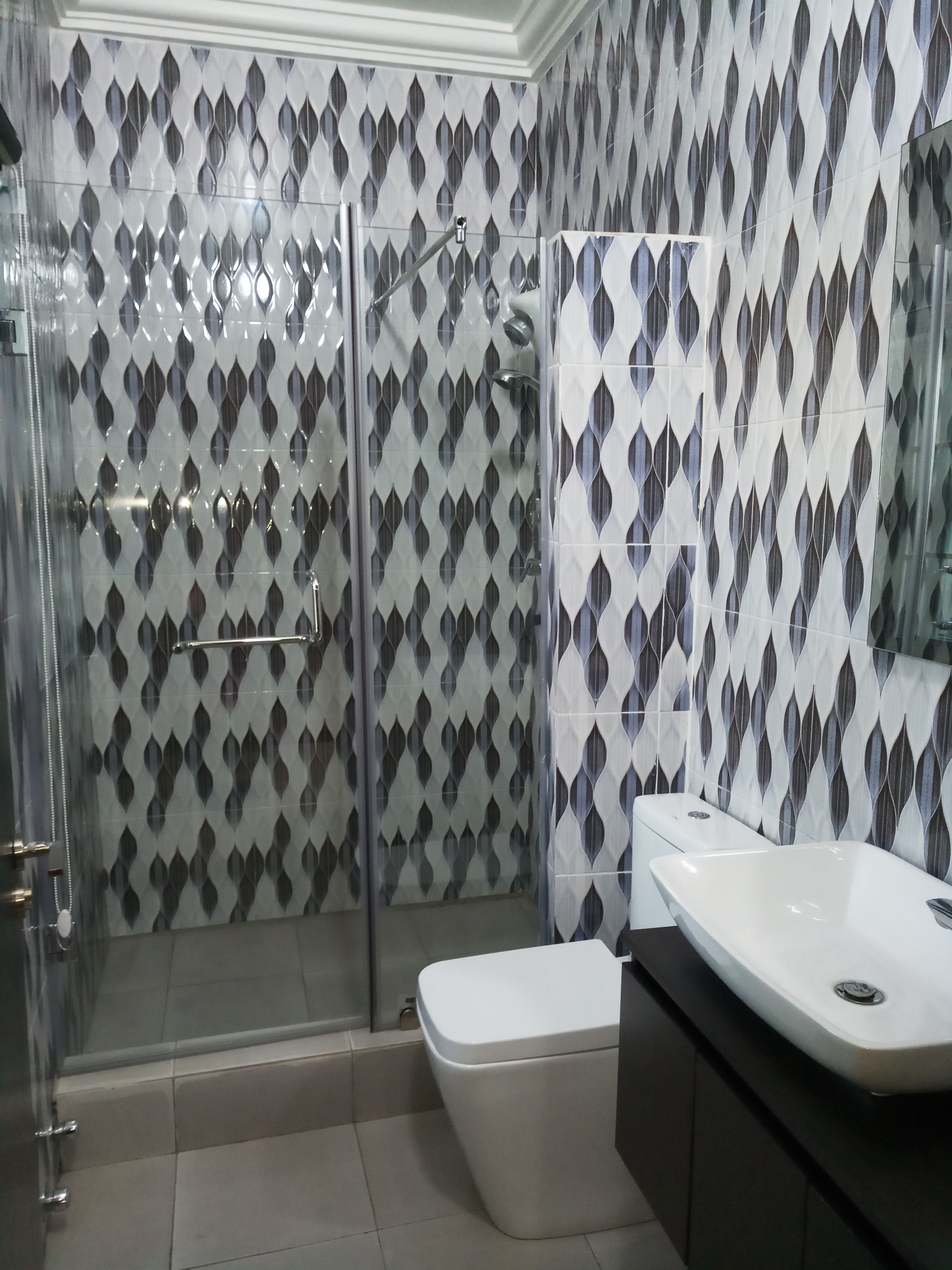 A bathroom with a shower, toilet, and sink.