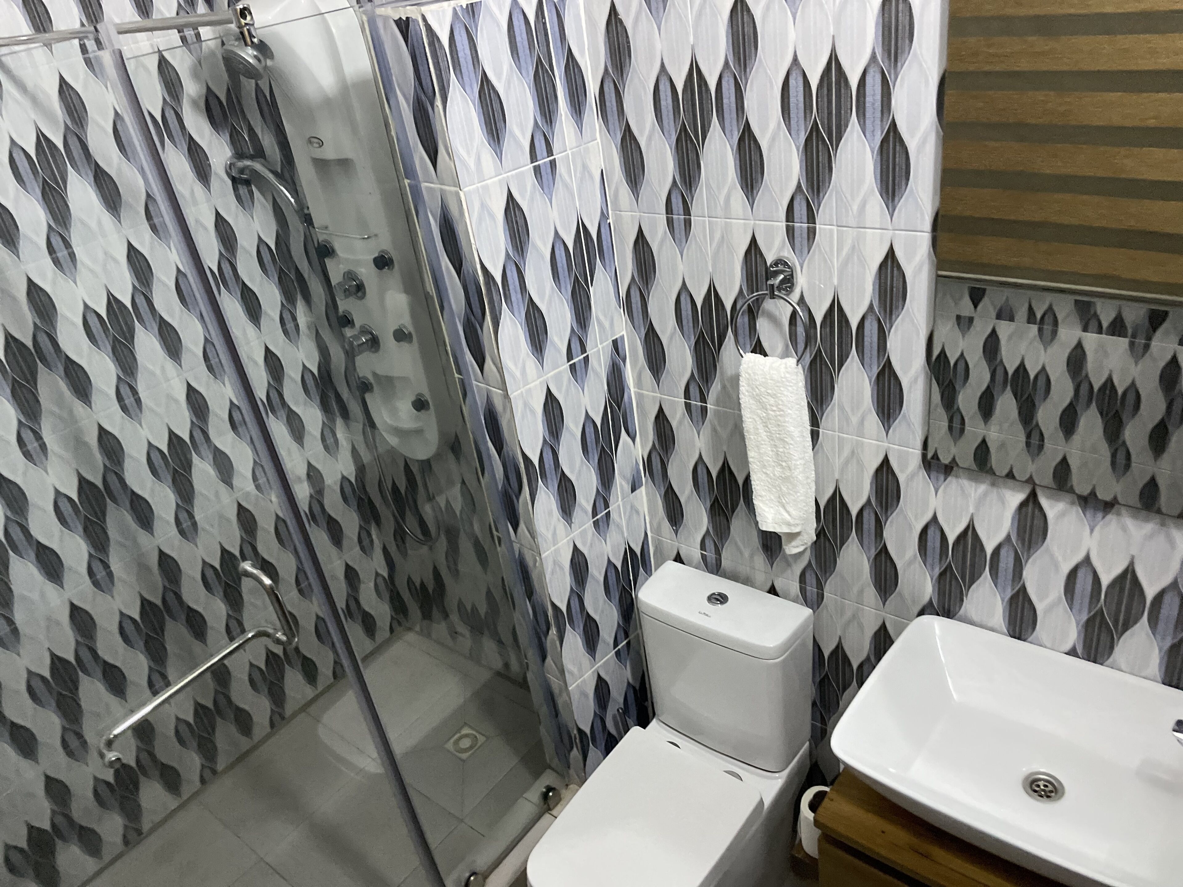 A bathroom with a shower, toilet, and sink.