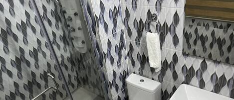 A bathroom with a shower, toilet, and sink.