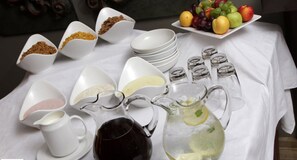 A table set with various food items, including fruits, condiments, and beverages.