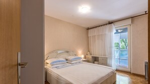 A bedroom with a bed, bedside table, and a window with curtains. - Apartment Gordana (ST) - One Bedroom Apartment (Split)