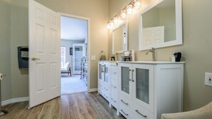 A hallway with a white door, a vanity with a mirror, and a chair. - Experience breathtaking views at Sedona Thunder Mountain Cottage, a spacious 3-bedroom retreat. (Sedona)