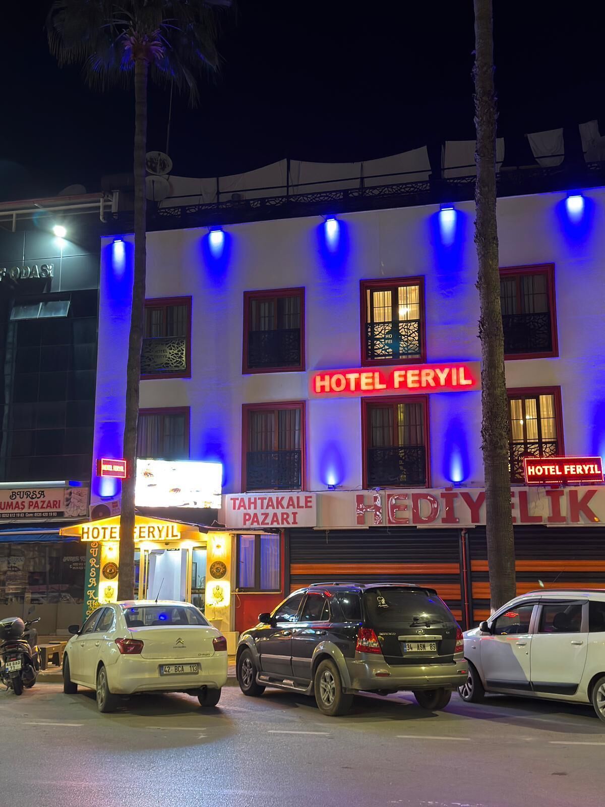 A building with multiple signs for 'HOTEL FERYIL' and 'TAHTAKALE PAZARI'.