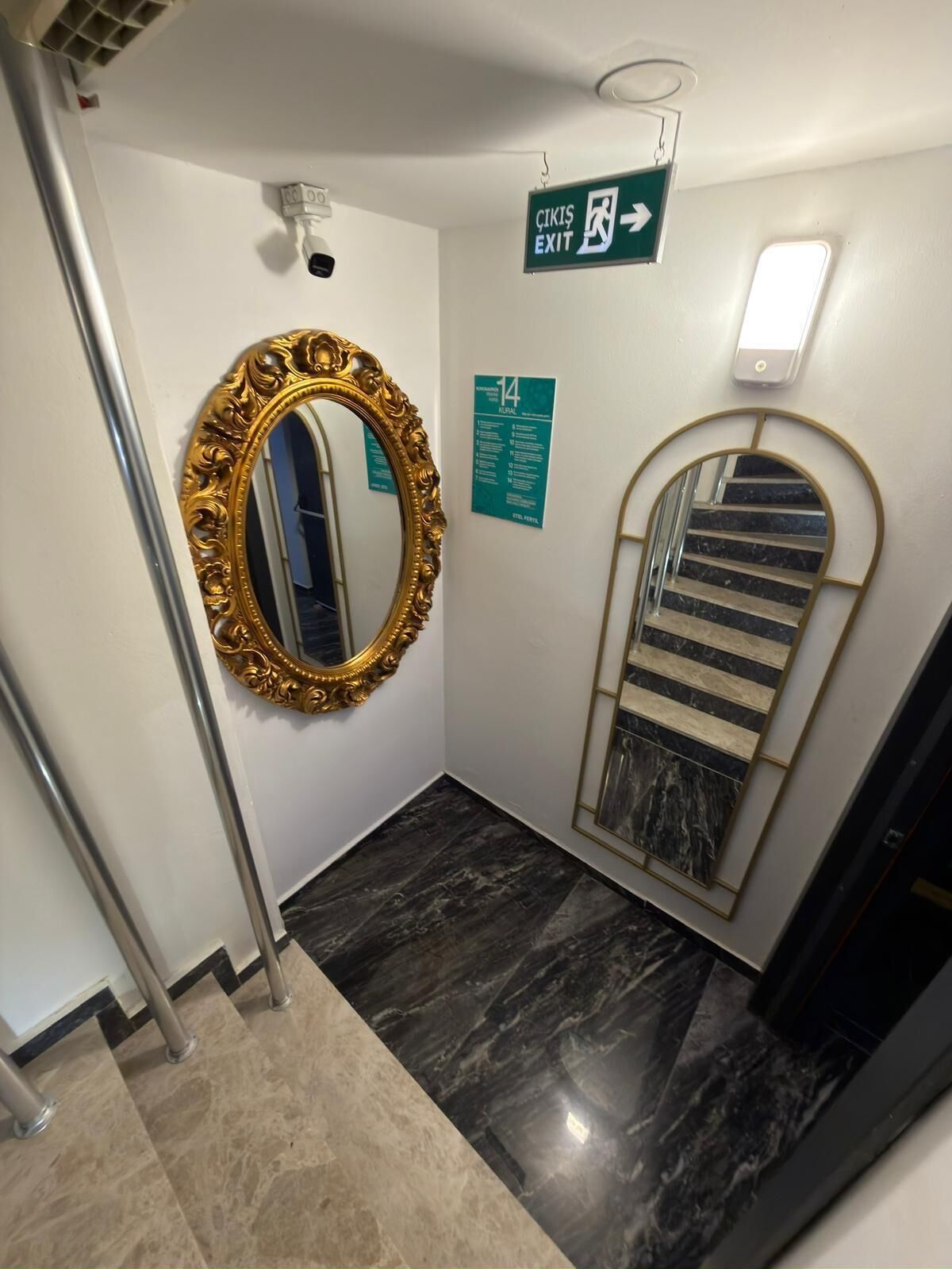Ein Flur mit Spiegel, Treppe und einem Notausgang.