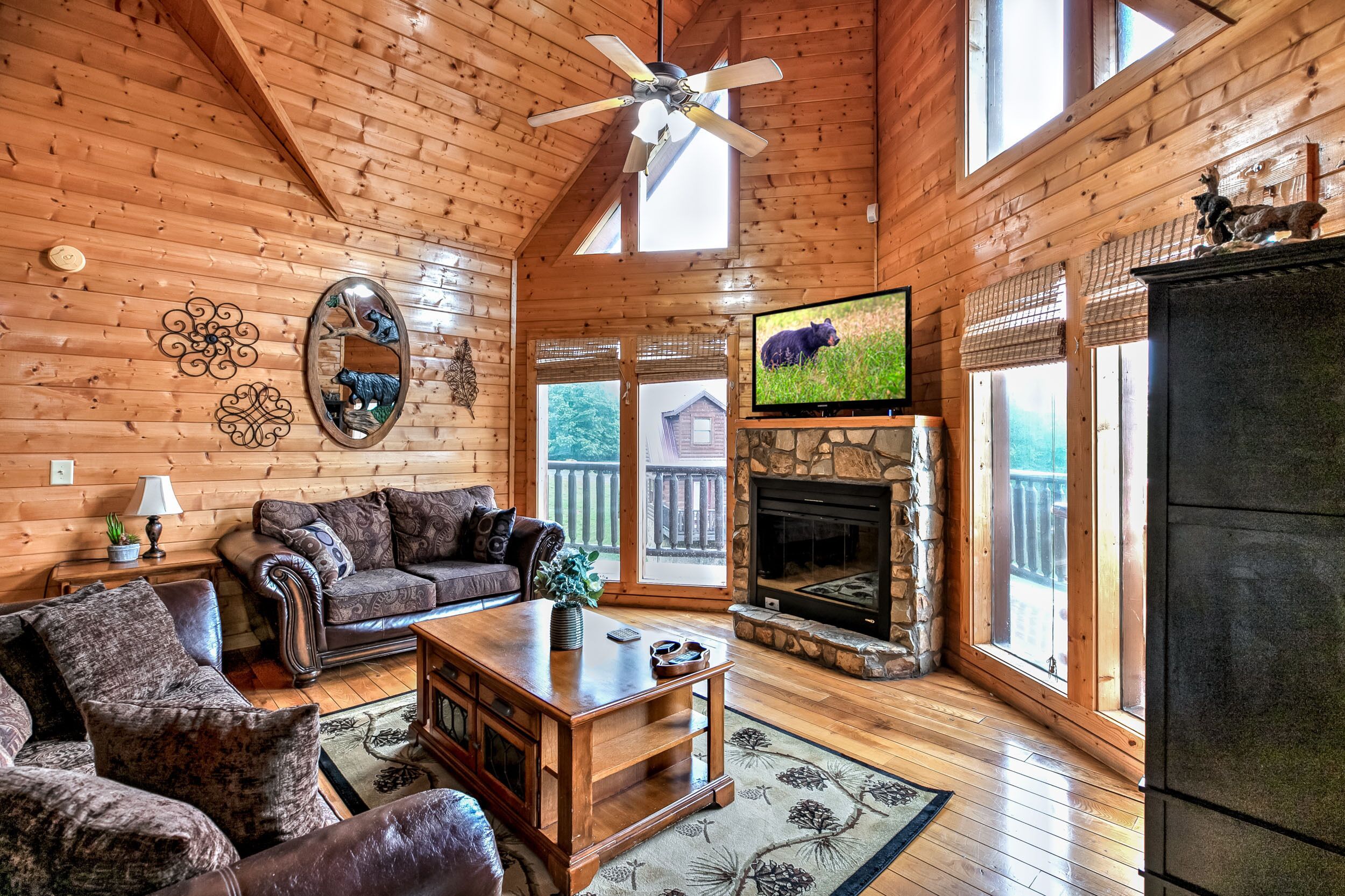 Un intérieur de chalet chaleureux avec une cheminée, des murs en bois et un téléviseur.