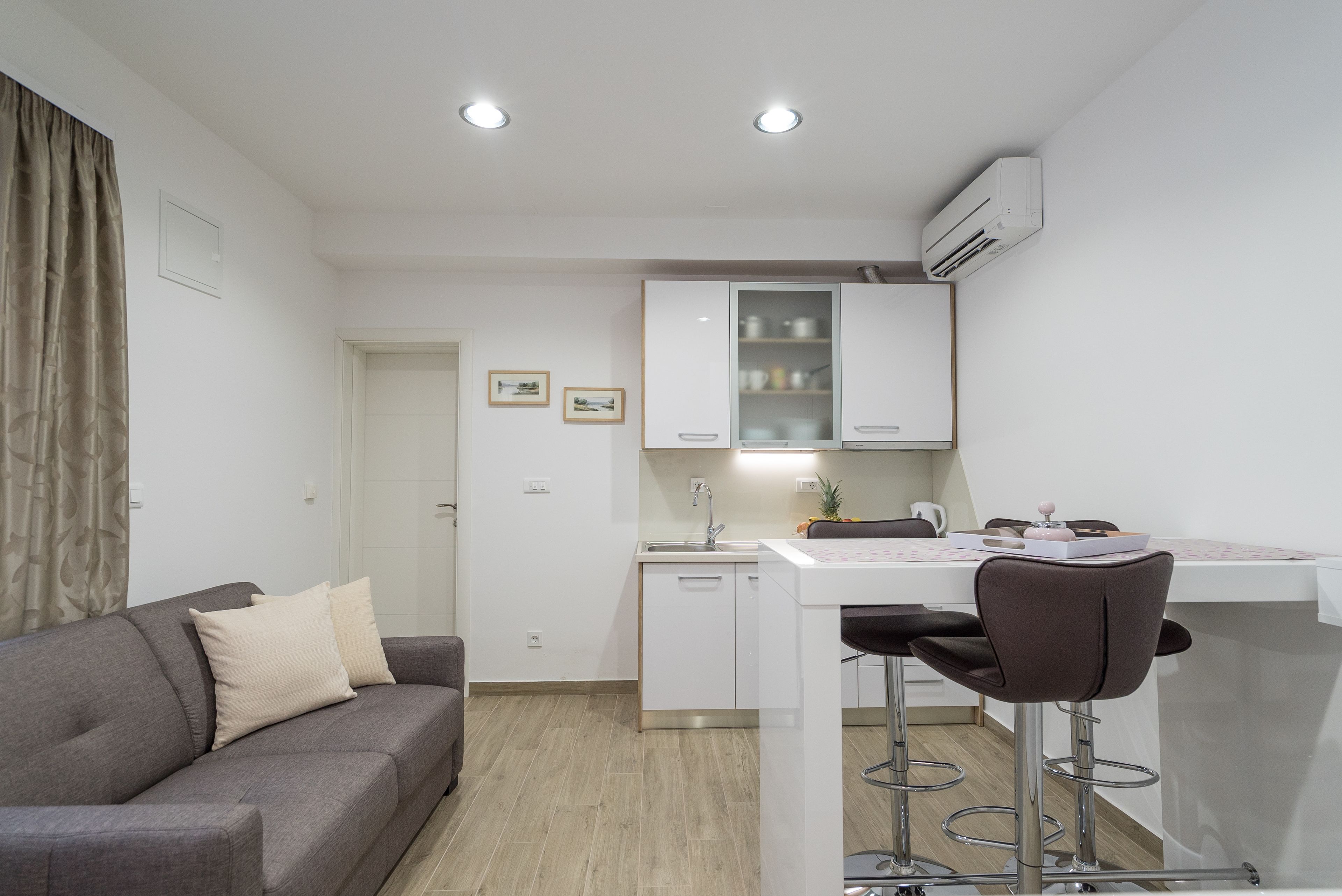 A compact living space with a kitchenette, a sofa, and a dining area.