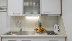 Cuina amb un rentapesos d'acer inoxidable, un plat de fruita, una tetera i una balança digital.