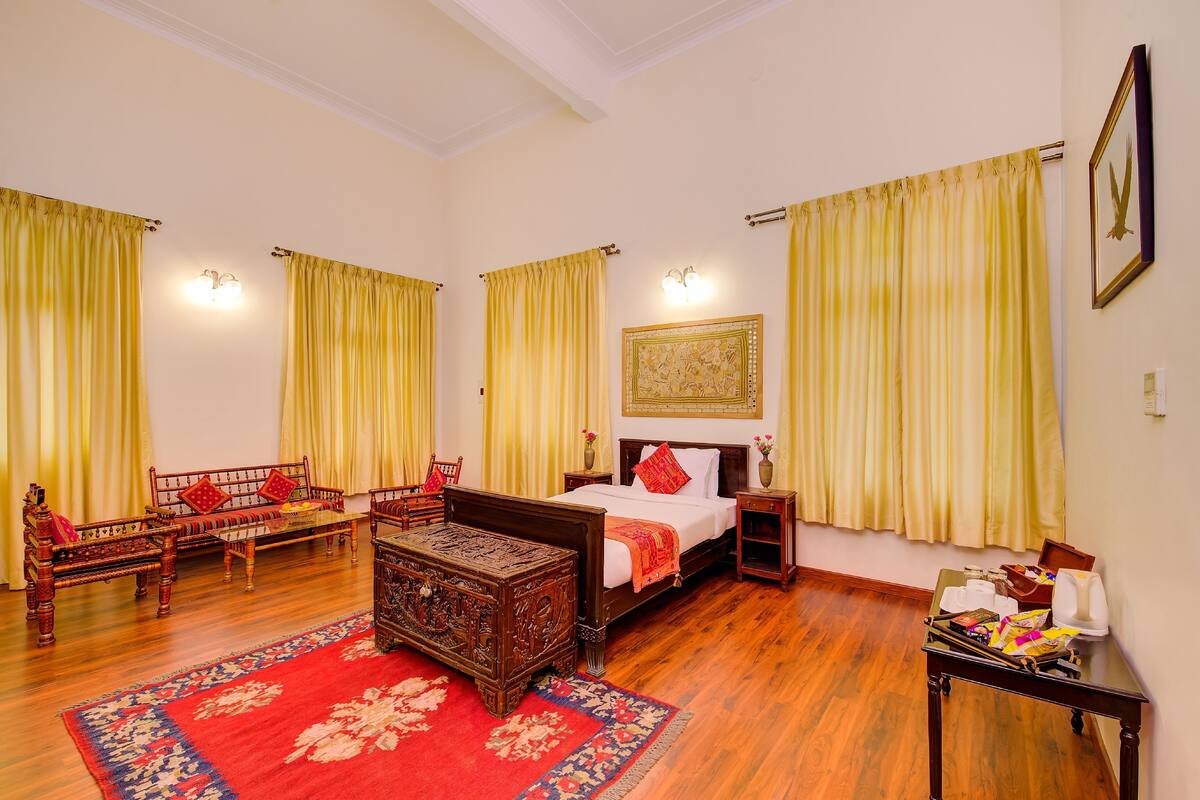 Une chambre de style traditionnel, avec un lit, des meubles en bois et des rideaux jaunes.