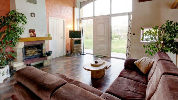 A spacious living room with a fireplace, a large sofa set, and a television. - Spacious cottage with private pool and pets allowed in Saint-Priest-la-Prugne (Saint-Priest-la-Prugne)