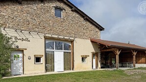 A stone building with a white door, a covered outdoor area, and a sign reading 'Grusel'. - Spacious cottage with private pool and pets allowed in Saint-Priest-la-Prugne (Saint-Priest-la-Prugne)
