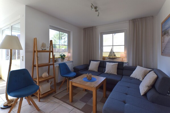 A living room with a sofa, chairs, a table, and a lamp. - Centrally located apartment for 4 people, south-west facing terrace, washing machine, WLAN (Ostseebad Prerow)