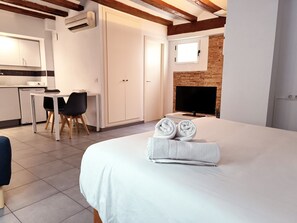 A hotel room with a bed, a TV, a fireplace, a desk, and a kitchen area. - Flats Friends Tetuan Studio (Valencia)