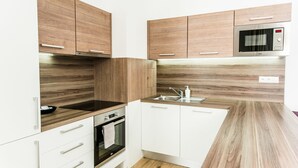 Una cocina moderna con armarios de madera, horno empotrado y microondas.