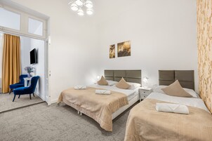 Habitación de hotel con dos camas, un escritorio y una silla.