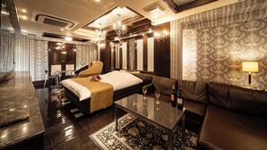 A modern hotel room with a large bed, a sofa, a coffee table, and a desk. - Lucky Sun (Nishinomiya)