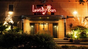 A hotel entrance with a neon sign reading "Lucky Sun" and a well-lit facade. - Lucky Sun (Nishinomiya)