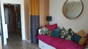 A bedroom with a bed, a mirror, and a wardrobe.