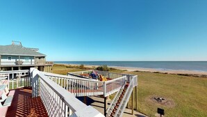 A beachside property with a deck, outdoor seating, and a view of the ocean. - Centurion: 3  BR, 2  BA House in Caplen, Sleeps 10 (Bolivar Peninsula)