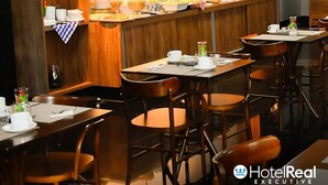 A hotel dining area with wooden paneling, a buffet setup, and multiple tables and chairs.