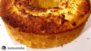 A round cake with a golden-brown crust, served on a white plate.