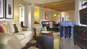 Una sala moderna con un sofá, una mesa de centro y un comedor con taburetes.