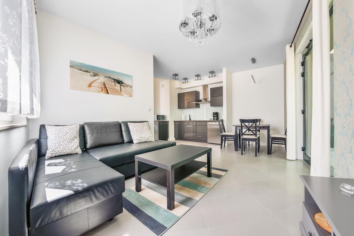 Un salon moderne avec un canapé, une table basse et un coin repas.