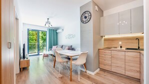 A modern kitchen with wooden cabinets, a built-in oven, and a countertop. - Apartamenty Sun & Snow Dwie Sosny (Ustronie Morskie)