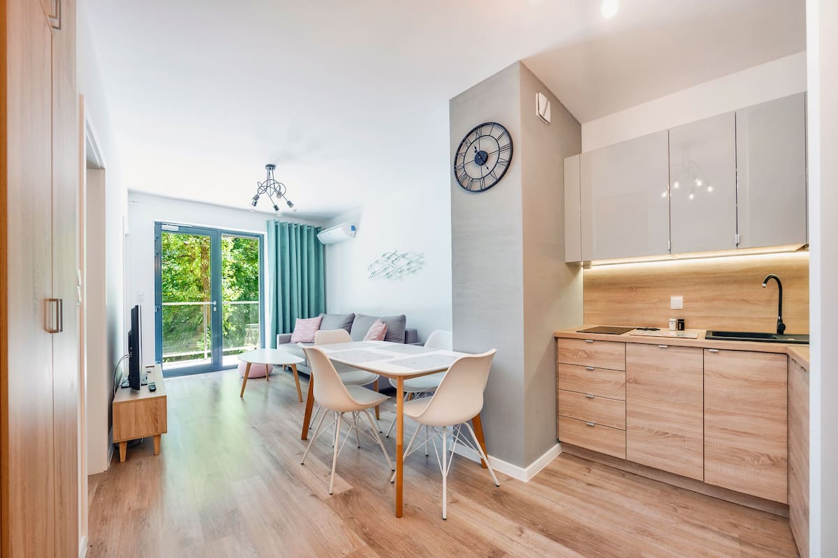 Une cuisine moderne avec des meubles en bois, un four encastré et un plan de travail.