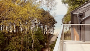A balcony with a view of a forest and a body of water. - Apartamenty Sun & Snow Dwie Sosny (Ustronie Morskie)