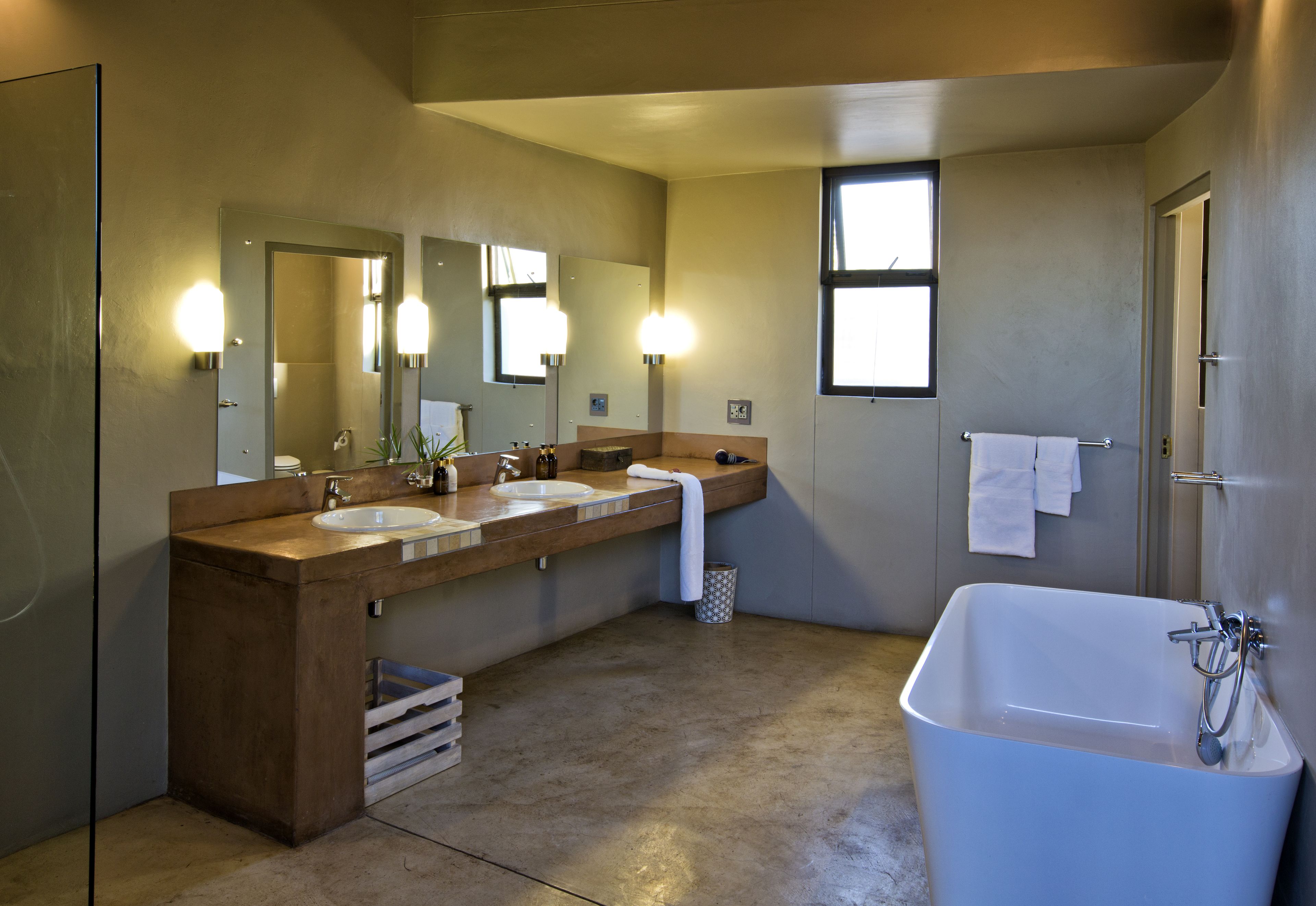 A bathroom with a large bathtub, two sinks, and a mirror.
