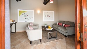 A living room with two sofas, a coffee table, and artwork on the walls. - Safarihoek (Kamanjab)