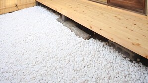 A traditional Japanese-style building with a wooden exterior, sliding doors, and a gravel ground. - (Guest House) Kiyomori no Baika (Shimogyo Ward)