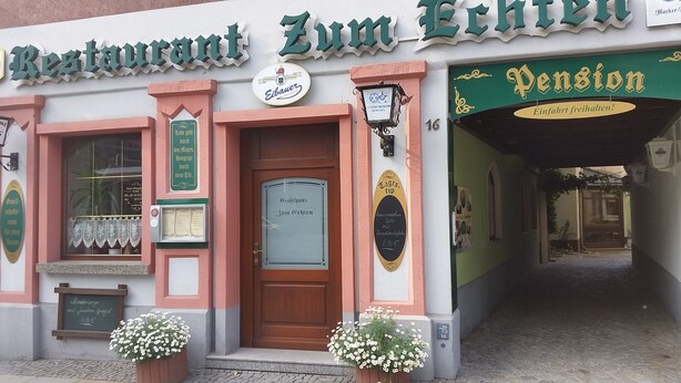 A restaurant with a traditional facade, a sign indicating 'Zum Eichen' and 'Pension' with a green and white color scheme. - Pension & Restaurant Zum Echten (Bautzen)