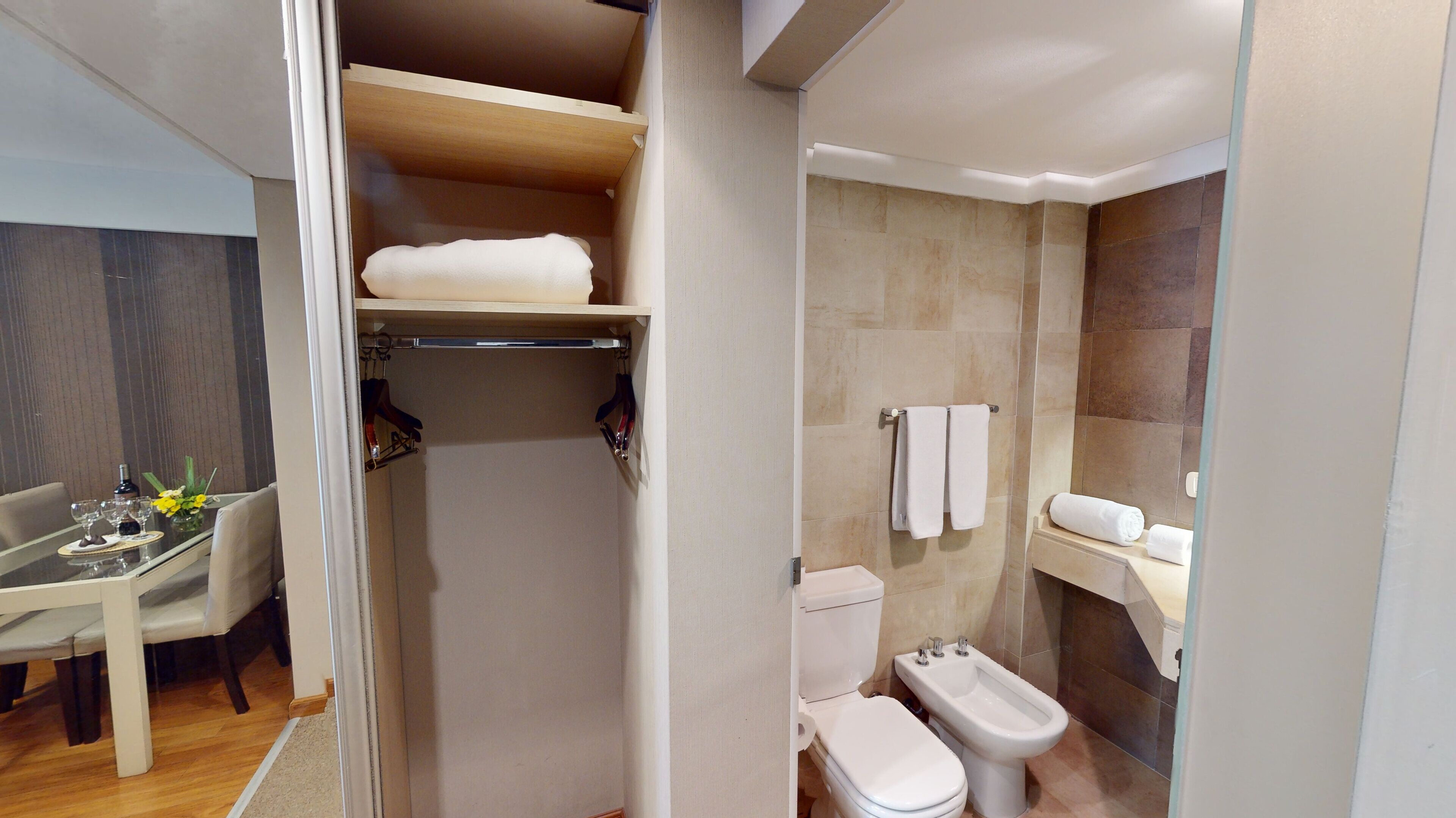 Un bany modern amb dutxa, vàter, bidet i paraigua per a tovalloles.