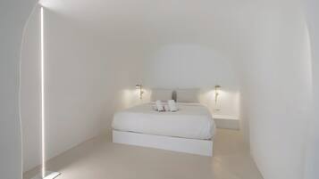 Un dormitorio minimalista con cama, lámparas de noche y una lámpara de pie.