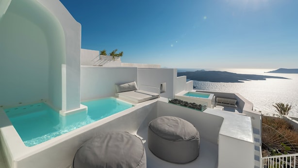 Une terrasse extérieure moderne dotée d’une piscine, de coins salon et offrant une vue sur la mer.